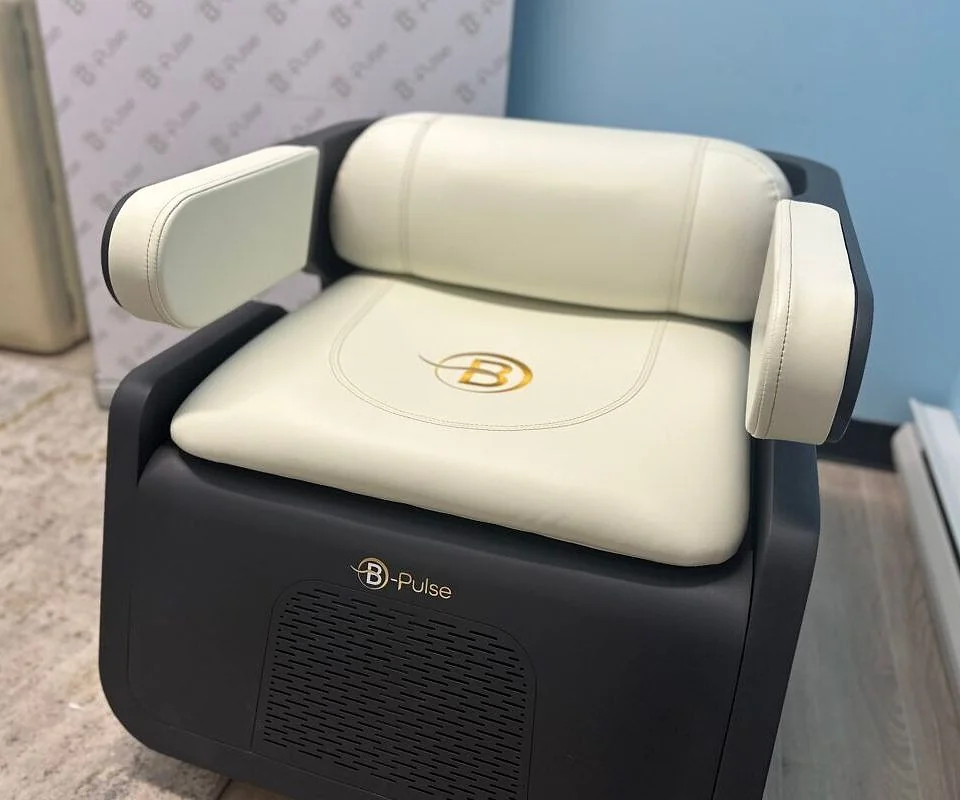La chaise B-PULSE de Pelvia Santé : un fauteuil en cuir crème, avec l'emblème doré B sur l'assise et une base noire profilée.